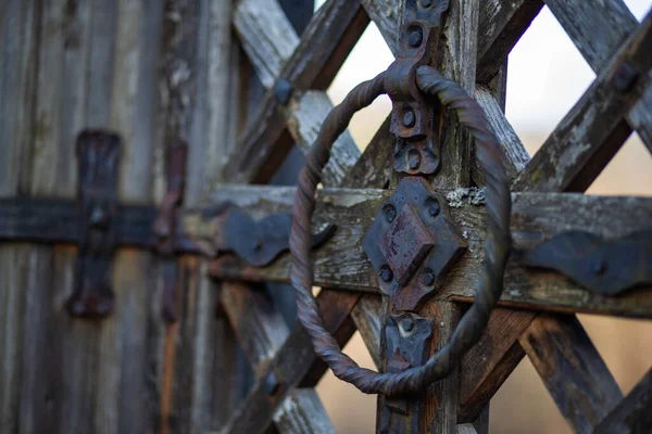 Eski, paslı demir kilitler ve demirci tarafından dövülmüş eski bir ahşap kapı.