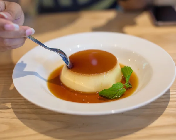 Delicious pudding with caramel and mint leaves. On a white backg — Stock Photo, Image