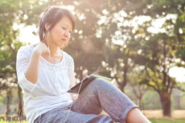 Woman using digital tablet in park — Stock Photo, Image