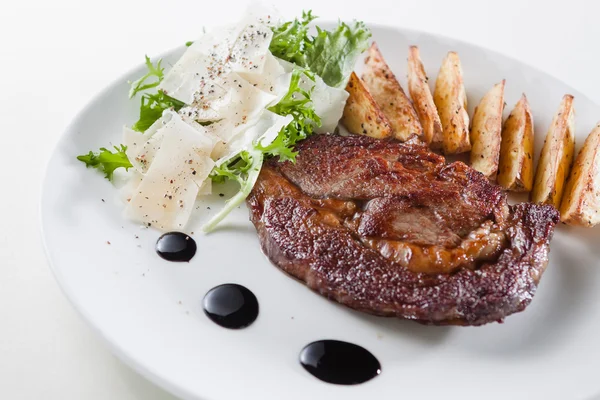 Naudanlihaa pihvillä ranskalaisilla perunoilla, salaatilla, kastikkeella — kuvapankkivalokuva