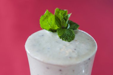 İrlandalı bir milkshake, çilek yaprağı koyu kırmızı zemin üzerine