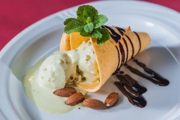 Piece of ice cream with chocolate syrup, almonds and strawberry — Stock Photo, Image