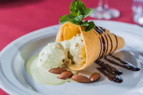 Piece of ice cream with chocolate syrup, almonds and strawberry — Stock Photo, Image