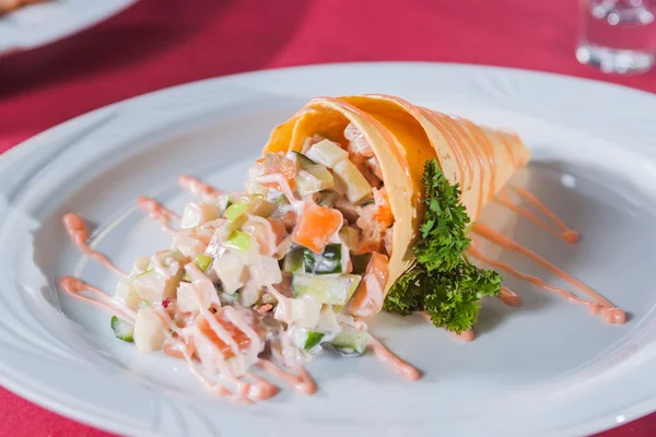 Ensalada en una salsa de cono de gofre y verduras en un plato blanco redondo —  Fotos de Stock
