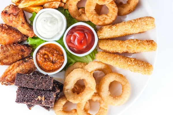 Queso a la parrilla, croutons y salsas en un plato redondo sobre ba blanca —  Fotos de Stock