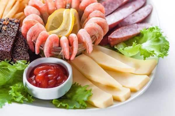 Assorted snacks: cheese, salami, shrimp, french fries — Stock Photo, Image