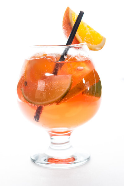 orange cocktail with lime in a hurricane glass