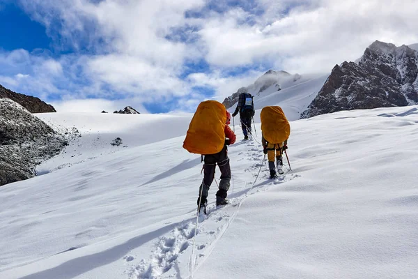 登山者の束雪の上に登る帽をかぶった山 — ストック写真