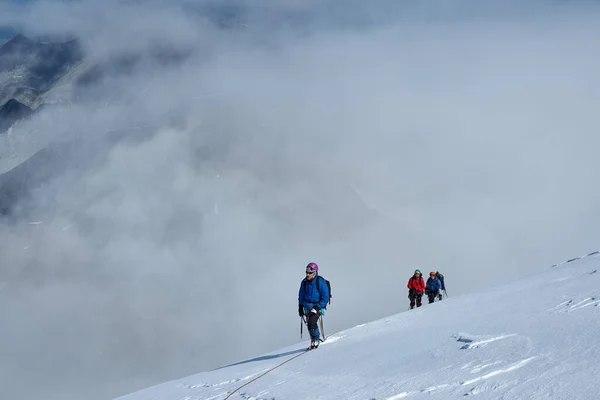 登山者の束雪の上に登る帽をかぶった山 — ストック写真