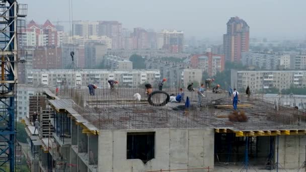 NOVOSIBIRSK, RUSSIA - 12 Mayıs 2020: İşçiler takviye ve formasyon kuruyor. Crane inşaat alanında çalışıyor. — Stok video