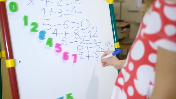 Children hands writing on white magnet board to learn numbers at home — Stock Video