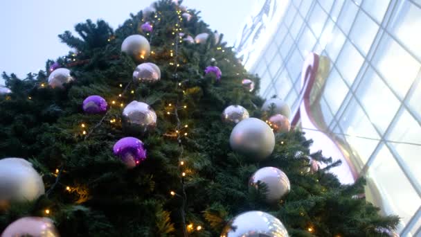 Close-up van een prachtige kerstboom versierd met kerstballen op straat — Stockvideo