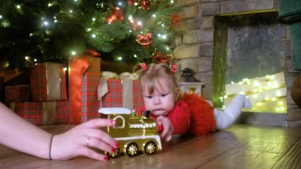 Kerst baby met speelgoed trein, boom, geschenken en ballen — Stockvideo