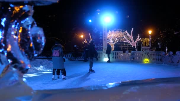 RÚSSIA, NOVOSIBIRSK - DEC 23, 2019: patinação no gelo Pista de Natal na praça da cidade à noite — Vídeo de Stock