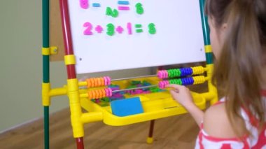 Çocuk abaküs kullanarak evde sayı ve hesap öğreniyor.