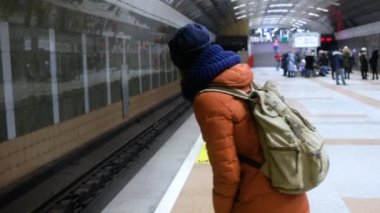Metro istasyonunda trende bekleyen bir kadın. Metro geliyor.