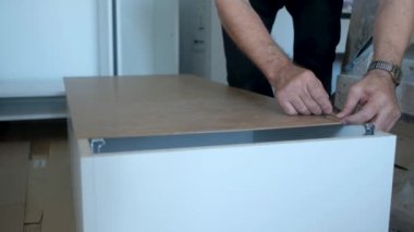 Yaşlı adam mobilya sondajı yapıyor. Evdeki yenileme işlerinde sondaj yapıyor.