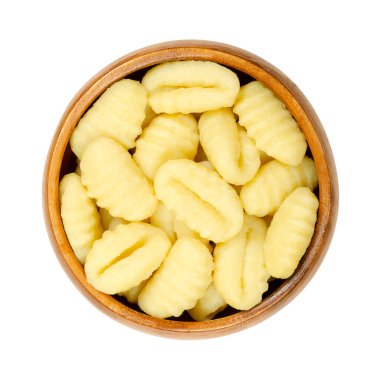 Çiğ gnocchi, tahtadan bir kasede İtalyan böreği. Küçük hamur parçalarından yapılmış, başparmak büyüklüğünde sırtları var. Patates ve sıradan buğday unundan oluşmuş, haşlanmaya ya da tavada kızarmaya hazır. Fotoğraf.