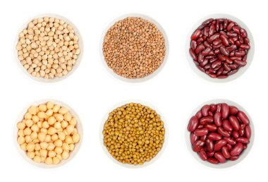 Kurutulmuş ve konserve nohut, kahverengi mercimek ve kırmızı böbrek fasulyesi, beyaz arka planda yukarıdan izole edilmiş beyaz kaselerde. Çiğ ve pişmiş Cicer arietinum, Lens culinaris ve Fhaseolus vulgaris tohumları.