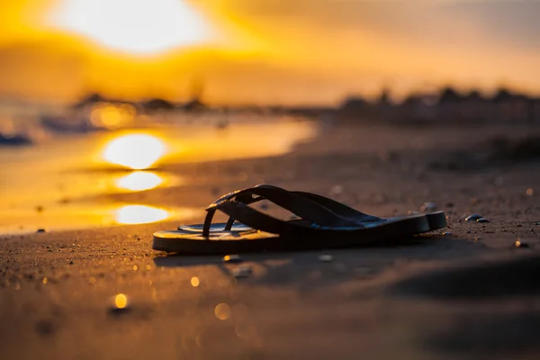 Сандалі на березі моря і захід сонця — стокове фото