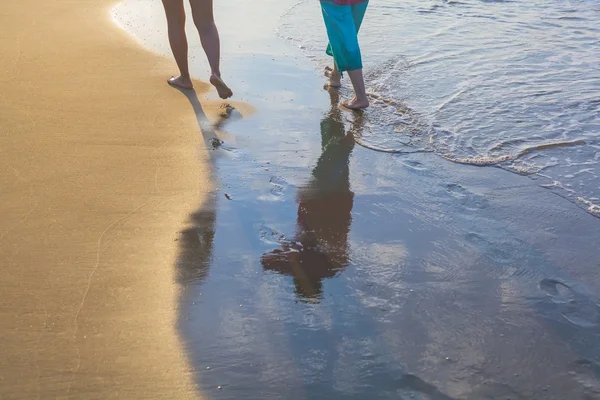 Vrouwen lopen op het strand tijdens zon — Stockfoto