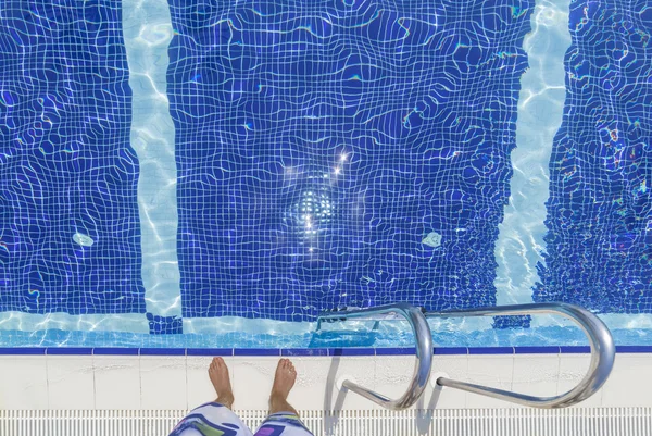 Uomo in piedi a bordo piscina — Foto Stock