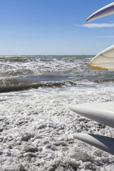 Surfplanken in de buurt van golvende zee — Stockfoto