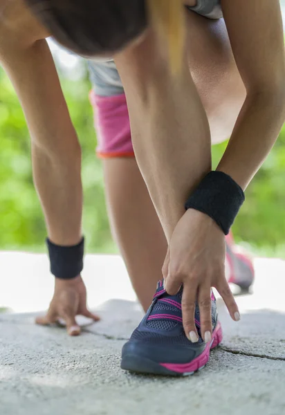 Vrouw jogger voorbereiden voor uitvoeren op park traject — Stockfoto