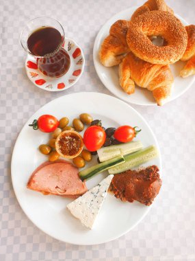 Geleneksel Türk kahvaltısı çay, simit, kruvasan, zeytin, bal, salam, beyaz peynir, domates ve kırmızı biber ezmesi ile sabahları masada..