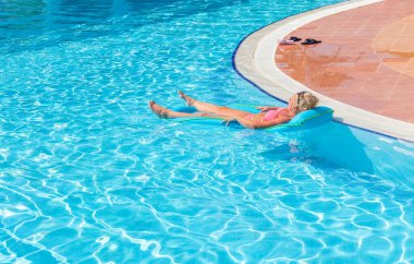 Antalya, Türkiye-29 Haziran 2021: Türkiye 'nin Antalya kentinde yaz aylarında bir otelde havuzda güneşlenen ve dinlenen turist kadın. Antalya, Rus, Ukraynalı, İngiliz, Polonyalı ve Alman turistler için popüler bir tatil beldesi.