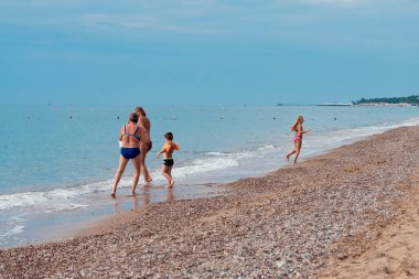 Antalya, Türkiye-29 Haziran 2021: Antalya 'da yaz aylarında Rus, Ukraynalı, İngiliz, Polonyalı ve Alman turistler için popüler bir tatil beldesi olan deniz kıyısında eğlenen mutlu turist ailesi.