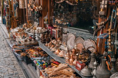 Türkiye 'de bir hediyelik eşya dükkanının vitrininde antika ahşap kaşıklar, alüminyum sürahiler, retro bıçaklar, bastonlar, oyuncak arabalar, retro fenerler, bakır tabaklar, nargile, tespih, süsler ve çeşitli eşyalar. 