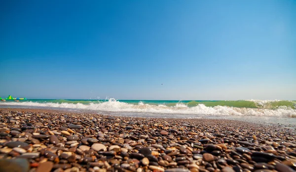 Laaghoekige Foto Van Kiezelstenen Aan Kust Golven Wazige Lucht Zomer — Stockfoto