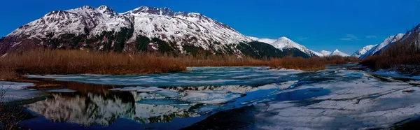 Hochauflösendes Panorama der alaskanischen Gebirgskette, das sich im teilweise zugefrorenen See widerspiegelt. — Stockfoto
