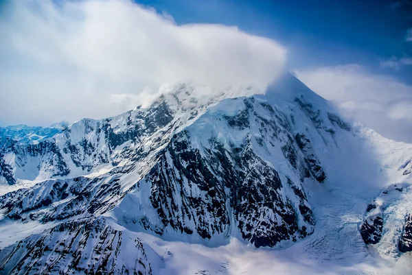 Vue aérienne impressionnante du mont McKinley, ou Denali, avec de la neige et des nuages soufflant dans des vents violents au sommet. Alaska . — Photo