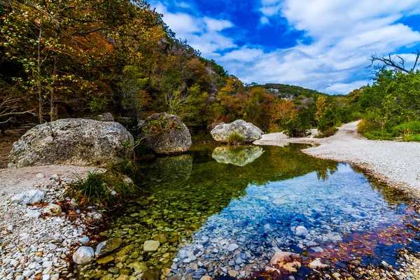 Een pittoreske scène vol prachtige fall gebladerte en grote granieten keien op een rustig kabbelende beek op verloren esdoorns state park in texas. — Stockfoto