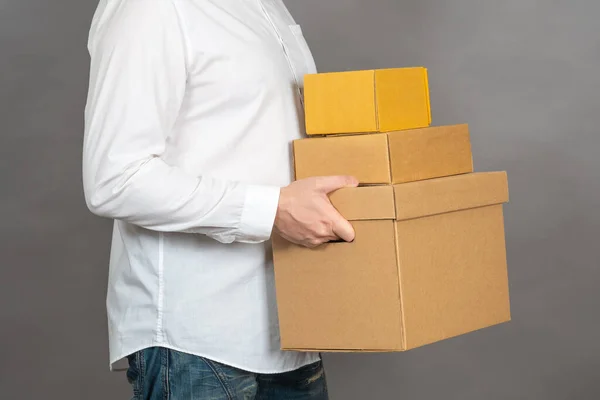 Man with parcels. Small business owner. Home delivery. Courier service. Online shopping with delivery. A man in a white shirt holds three boxes. Delivery business.