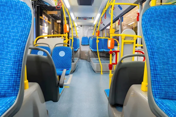 interior of bus. Modern public transport. Bus with blue seats. Yellow handrails with validators on bus. City vehicle. Concept is modern public transport. Autobus inside view. City trolleybus