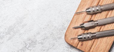 Tahta tezgahta demir kazıyıcıları var. Bozuk paraların mekanik temizliği ve arkeolojik eşyalar