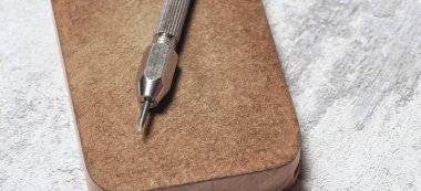 Tahta tezgahta demir kazıyıcıları var. Bozuk paraların mekanik temizliği ve arkeolojik eşyalar