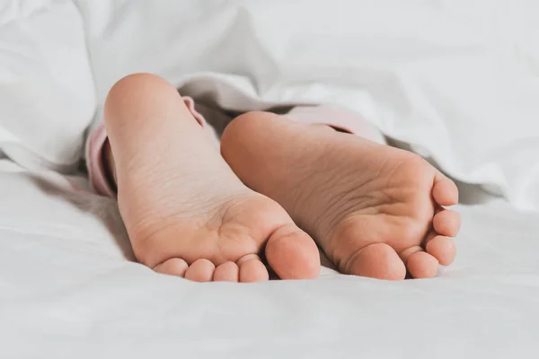 Childs 'ın bacakları beyaz çarşaflarla kaplı. Ev konforunun sıcaklığı
