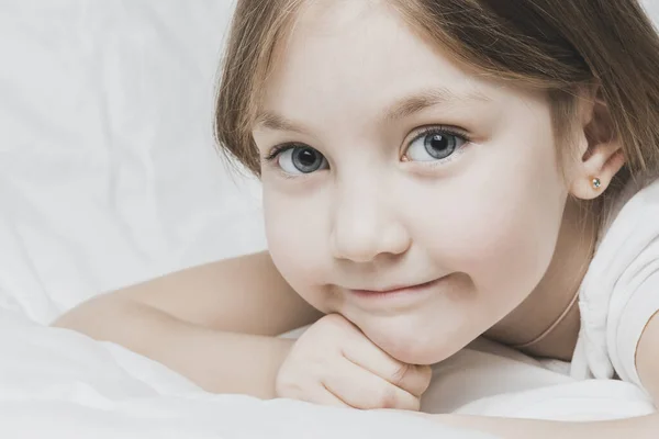 Schöne Kleine Mädchen Liegt Auf Dem Bett Mit Weißer Bettwäsche — Stockfoto