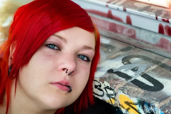 Redhead girl with piercing on graffiti background — Stock Photo, Image