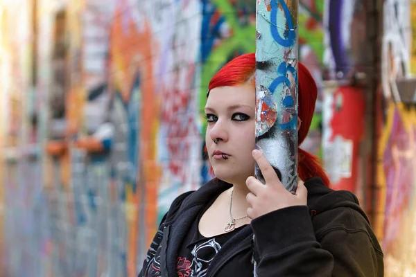 Redhead woman stands in front of graffity wall — Stock Photo, Image