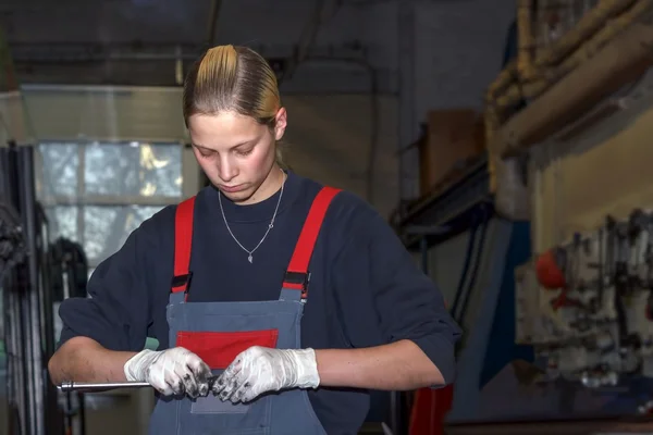 Jeune femme travaillant dans un atelier de réparation automobile — Photo