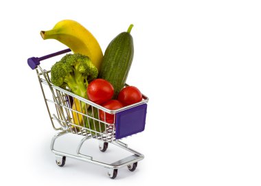 Mixed fruit and vegetables in a mini shopping cart, isolated on