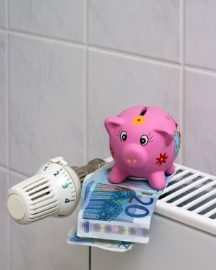 Piggy bank with radiator thermostat saving heating costs clipart