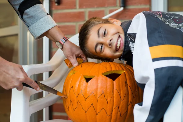 Boy holding jack-o-latern from big pumpkin Stock Image