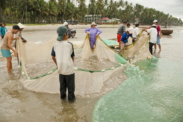 Vietnamita puxar seu seine para fora na praia em Mui Ne, Vietnam . — Fotografia de Stock