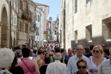 Tourists on a street of Santiago de Compostela. clipart